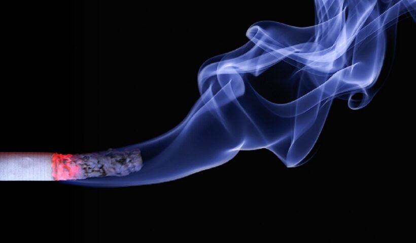 Cigarro aceso soltando fumaça com fundo preto no cenário. Imposto do Pecado deverá ser criado para produtos nocivos
