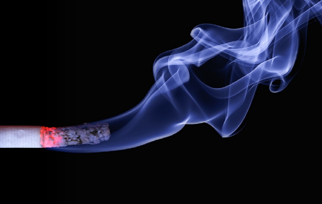 Cigarro aceso soltando fumaça com fundo preto no cenário. Imposto do Pecado deverá ser criado para produtos nocivos