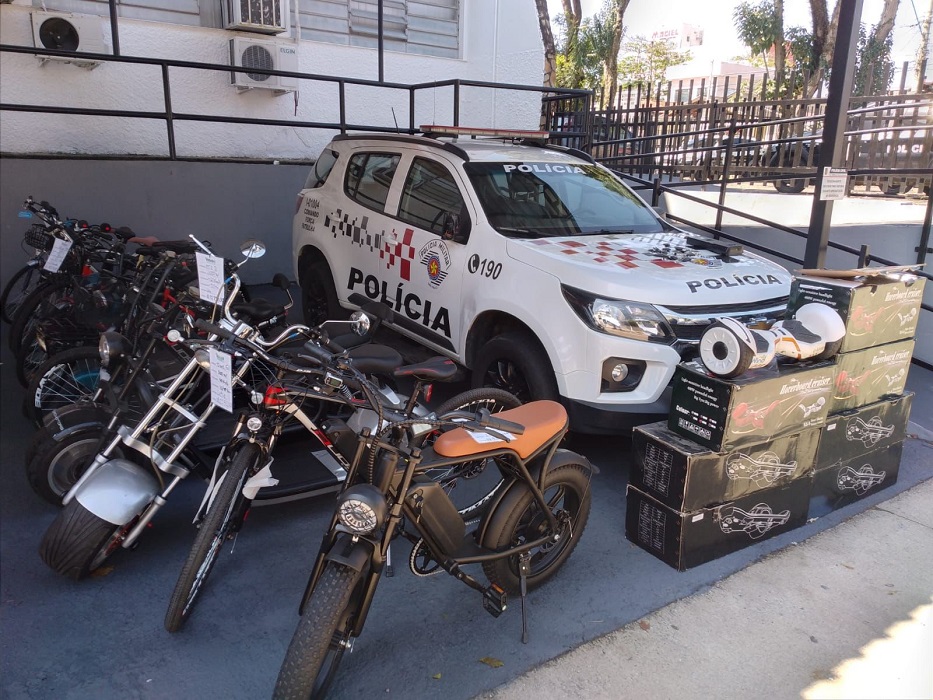 Motos e bicicletas elétricas furtadas ao lado de viatura da PM