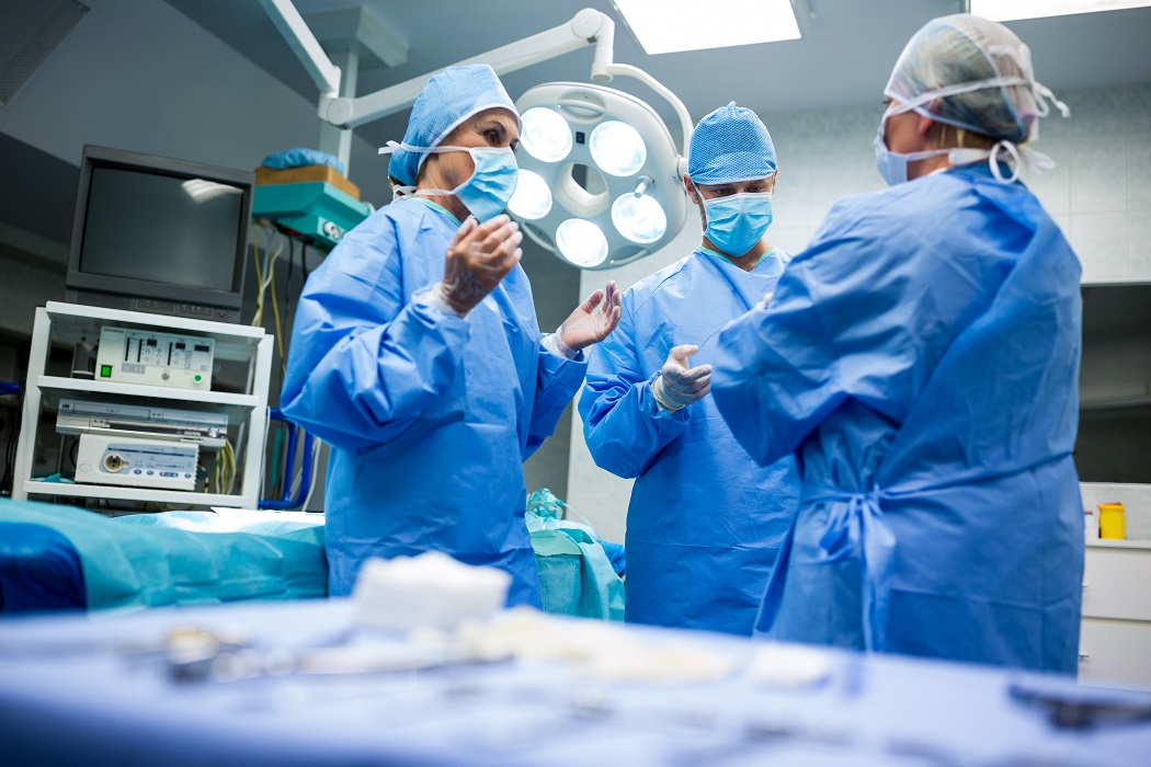 Cirurgiões e enfermeiros interagindo entre si na sala de operação do hospital. SP inicia repasses para o pagamento do novo piso da enfermagem