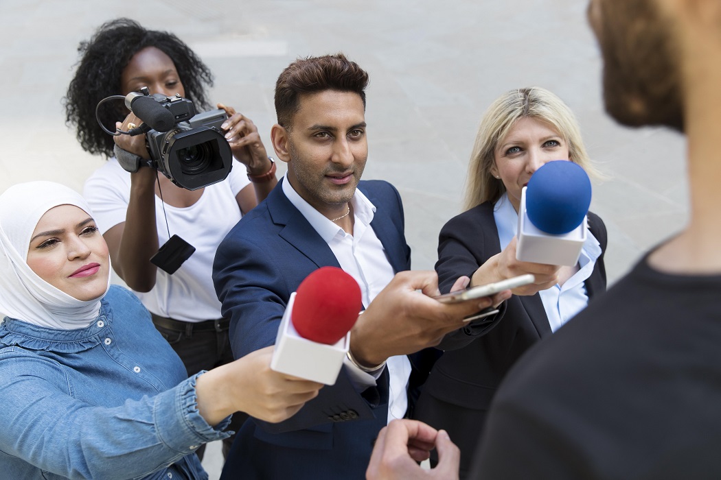 Imagem de repórteres que seriam europeus, entrevistando uma pessoa vista de costas. Matéria fala sobre importância de se ter um segundo idioma