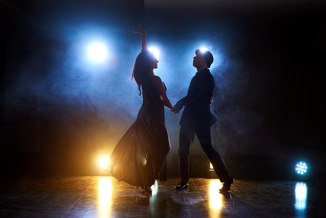 Dançarinos habilidosos se apresentando na sala escura sob a luz e a fumaça do concerto. Casal sensual realizando uma dança contemporânea artística e emocionante. Estão abertas as inscrições para a Escola de Artes Fêgo Camargo, em Taubaté