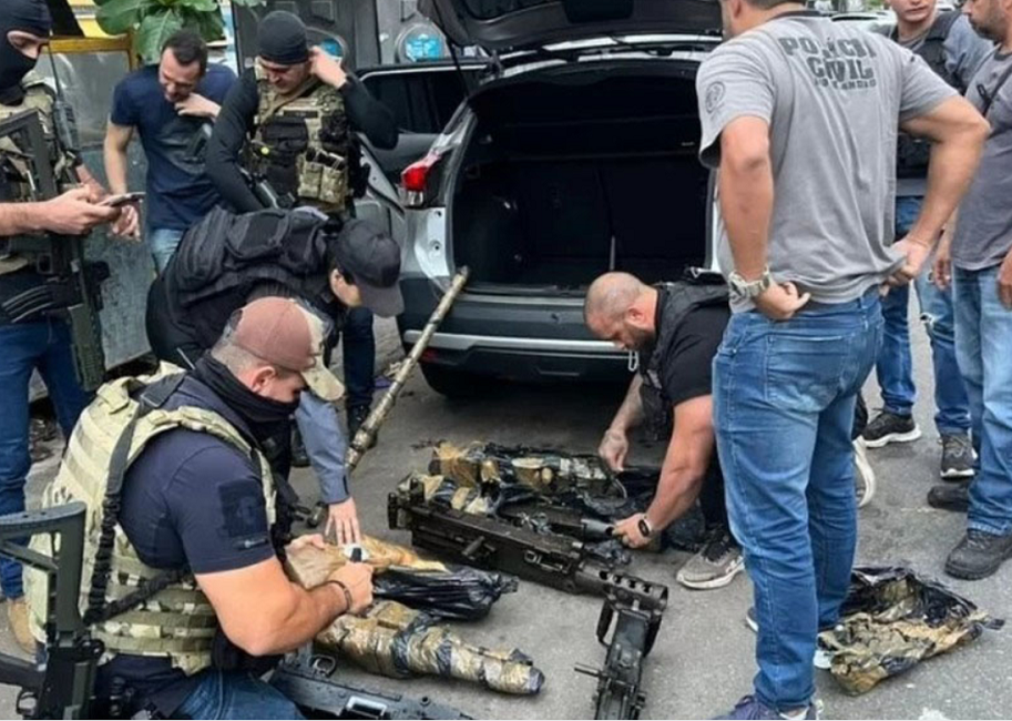 Policiais civis averiguando armas que estavam po porta-malas de veículo. Polícia Civil recupera mais nove armas furtadas do Arsenal do Exército, em Barueri (SP)
