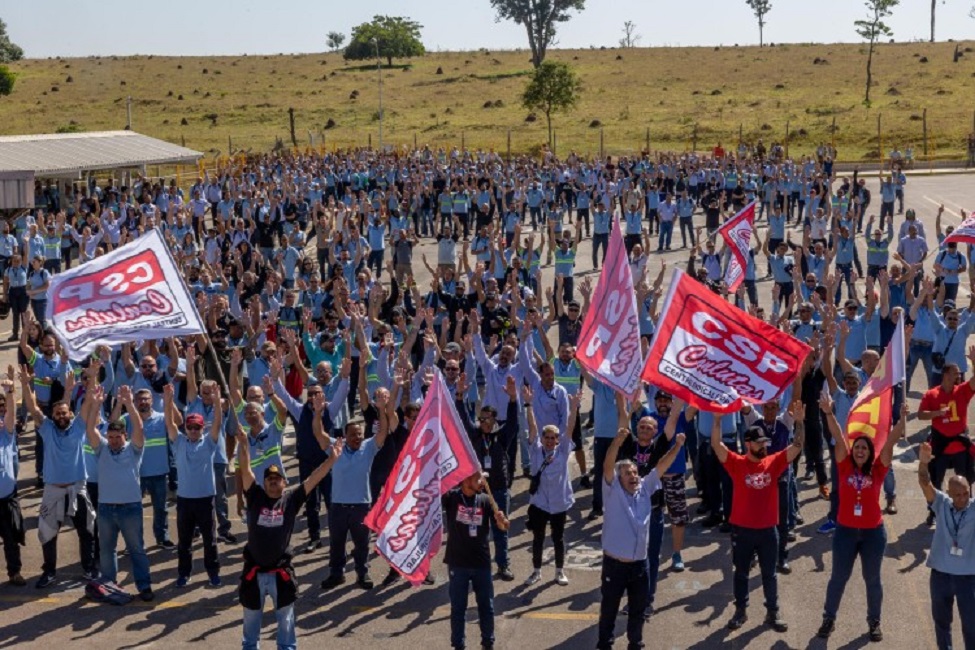 Tranalhadores da GM levantam os braços para aprovar fim da greve. Termina a greve na GM após acordo para suspender 1,2 mil demissões