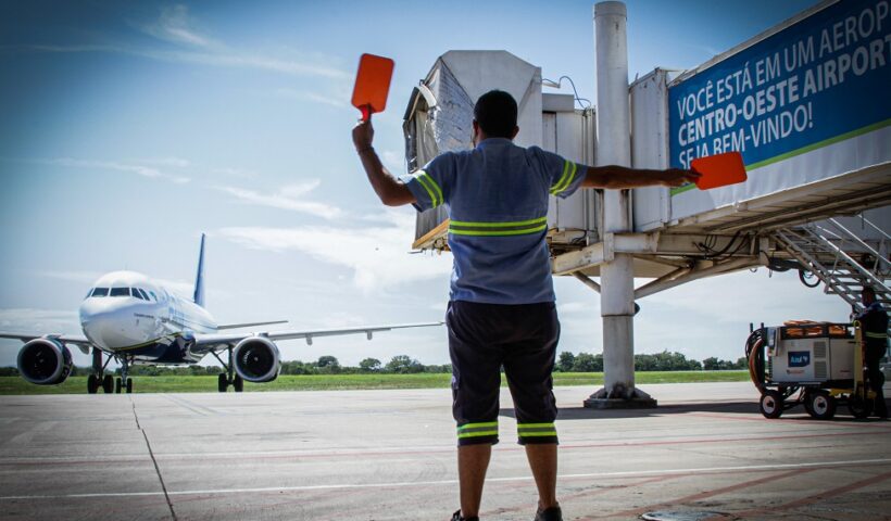 operador de tráfego de aeroporto de costas orientando piloto de avião. Olha o golpe! Criminosos usam programa de passagens aéreas Voa Brasil para aplicar fraudes