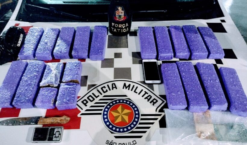Tijolos de maconha por cima do capô de viatura da PM. PM prende infrator com cerca de 10 kg de maconha, em Guaratinguetá