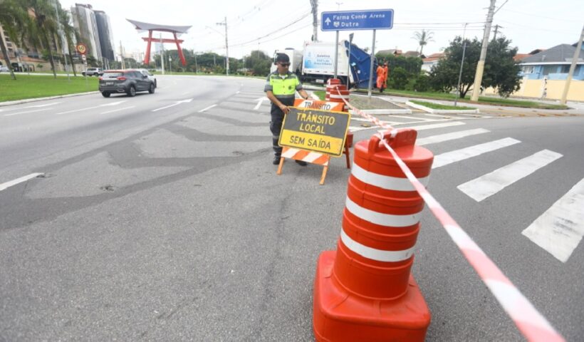 Agente de mobilidade interdita via com placa de sinalização em SJC. Via Oeste, em São José será interditada neste domingo para eventos esportivos