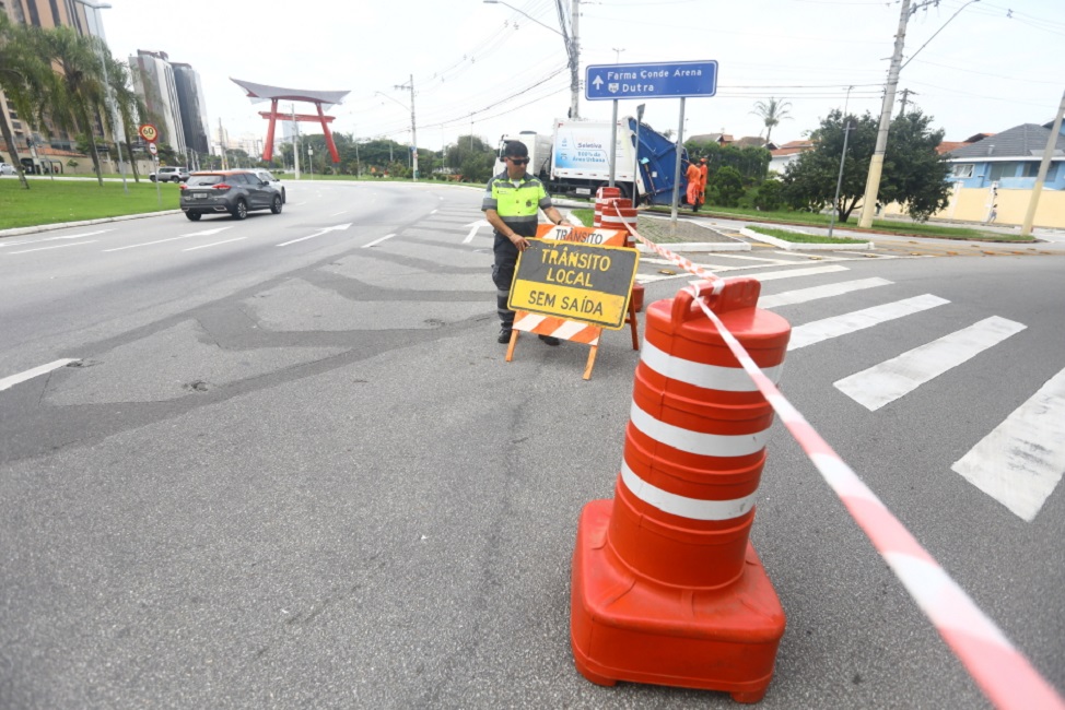 Agente de mobilidade interdita via com placa de sinalização em SJC. Via Oeste, em São José será interditada neste domingo para eventos esportivos