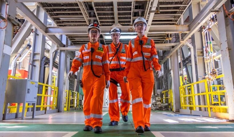 três funcionários da petrobras uniformizados em plataforma de petróleo. Petrobras divulga edital de concurso com com mais de 6,4 mil vagas e salário inicial de R$5,8 mil