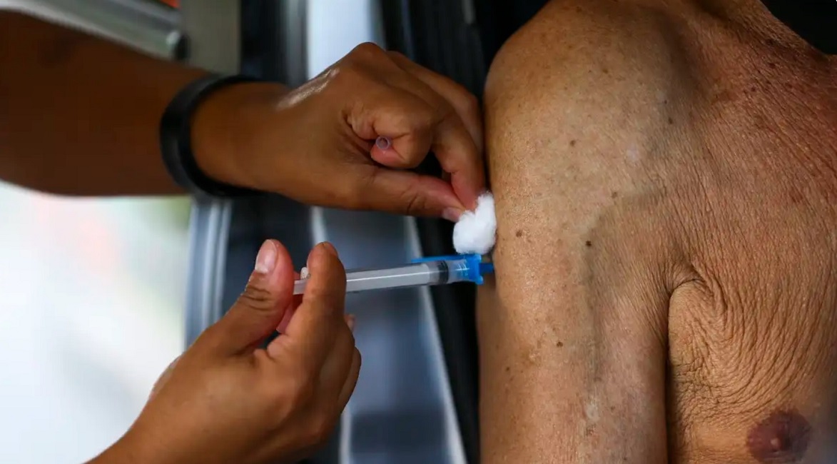 Mão de enfermeira vacinando braço de homem idoso. Registro de vacina contra bronquiolite é aprovado pela Anvisa