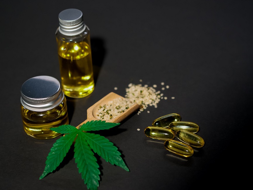 folha de maconha ao lado de medicamentos à base de cannabidiol.