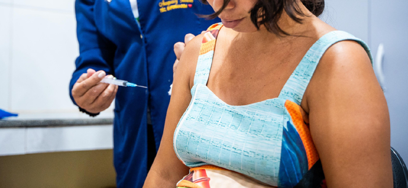 Mulher sendo vacinada por agente de saúde. Ministério da Saúde incorpora vacina contra a dengue no SUS