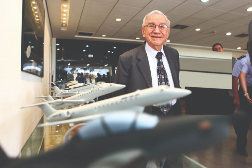 Ozires Silva, posando ao lado de miniaturas de aviões da Embraer