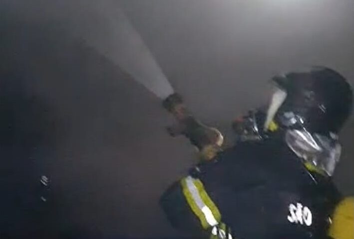 Bombeiro com mangueira para conter incêndio. Incêndio atinge casa no bairro Cocaia, em Ilhabela