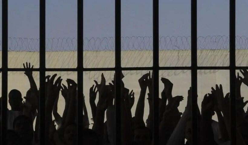 mãos de presos vistas em cela de cadeia. Senado Federal aprova fim da “saidinha” de presos
