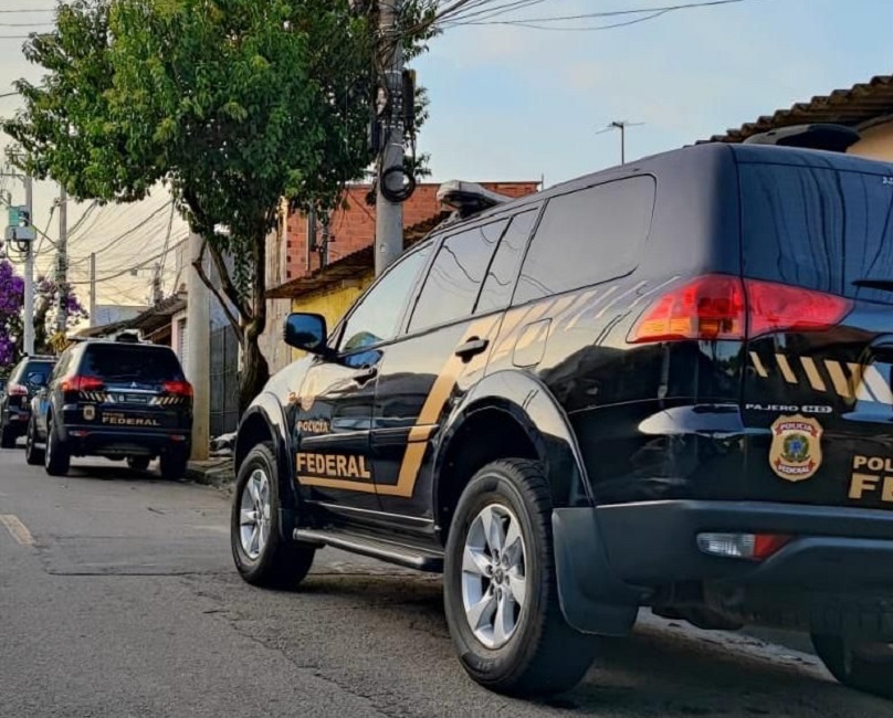 Viaturas da PF estacionados em rua. Polícia Federal prende suspeito de crimes virtuais em Taubaté, SP