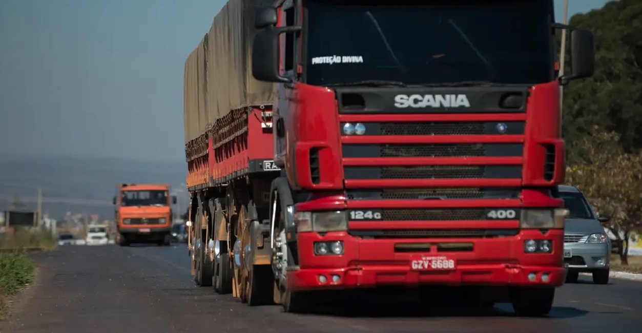 Caminhão vermelho em rodovia. Atenção! Motoristas têm até o dia 31 para fazer exame toxicológico