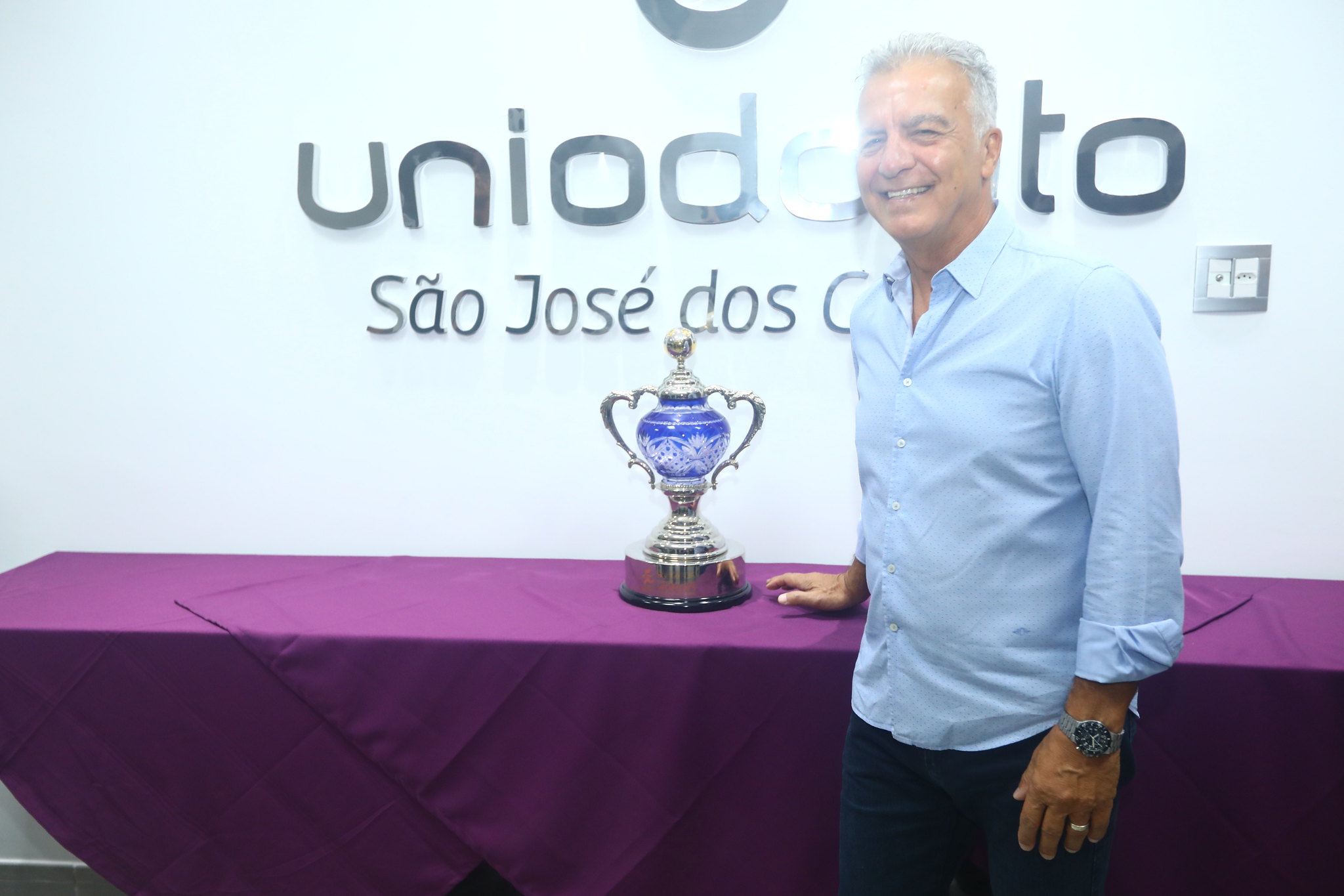 Oscar Constantino ao lado do troféu do Mundial Feminino de 2014 conquistado pelo São José