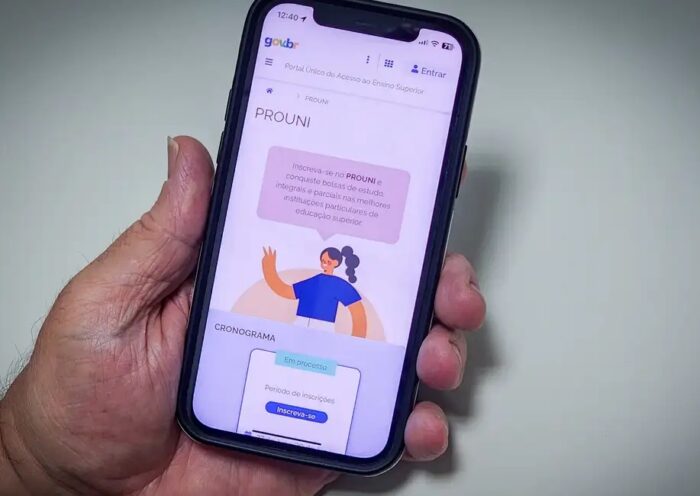 mão segura celular com app do prouni em tela