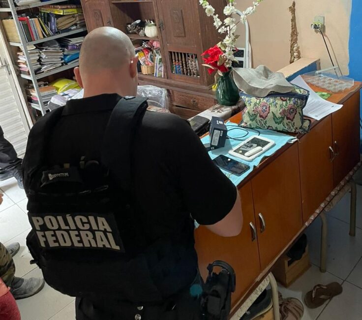 Agende da PF, de costas, dentro de imóvel de suspeito. Polícia Federal realiza operação contra abuso sexual infantojuvenil em Caçapava