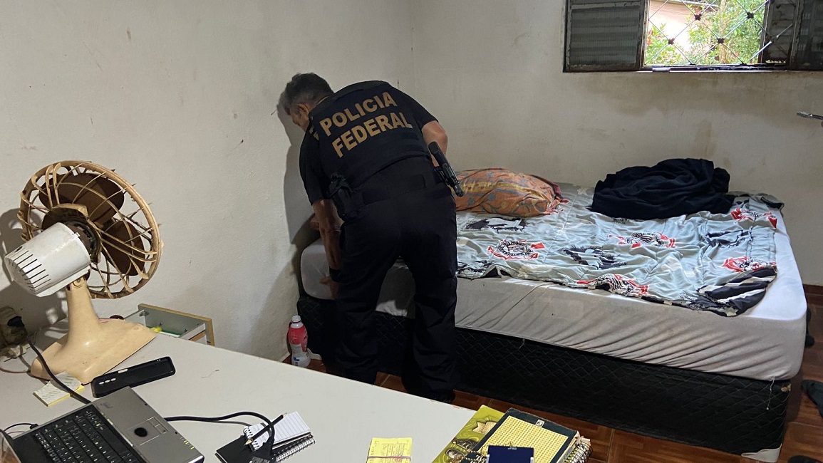 Agente da FP checa cama de suspeito. Operação da Polícia Federal combate abuso sexual infantojuvenil em Paraibuna, SP