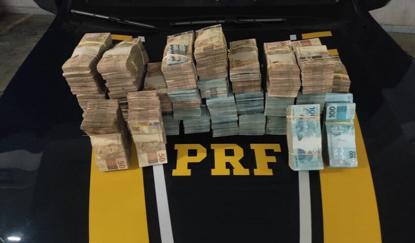 Dinheiro apreendido sobre capô de viatura da PRF. VÍDEO: PRF apreende mais de R$ 1 milhão sem origem comprovada na Via Dutra, em Jacareí