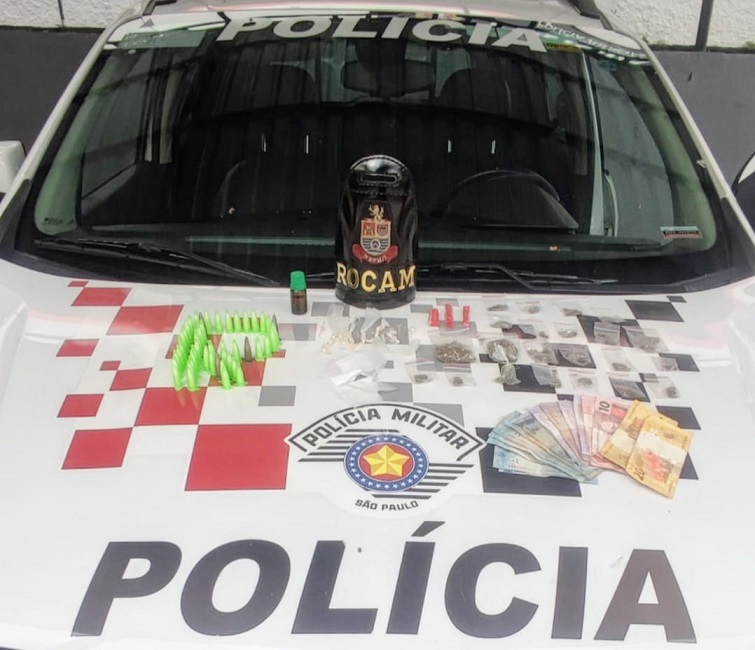 drogas apreendidas expostas sobre capô de viatura da PM