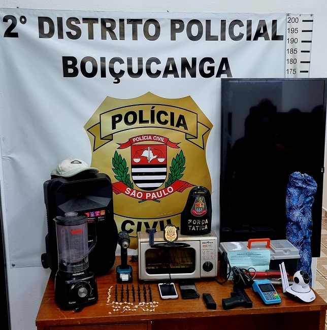 drogas celulares em sobre uma mesa com bandeira da polícia civil de são sebastião. Megaoperação da Polícia Civil prende 62 pessoas na região de São José dos Campos