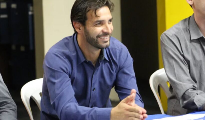 Explosão em restaurante fere familiares do ex-presidente do EC Taubaté, Gilsinho. Foto mostra o ídolo do clube sentado em uma cadeira, com uma camisa azul e apoiado em uma mesa.