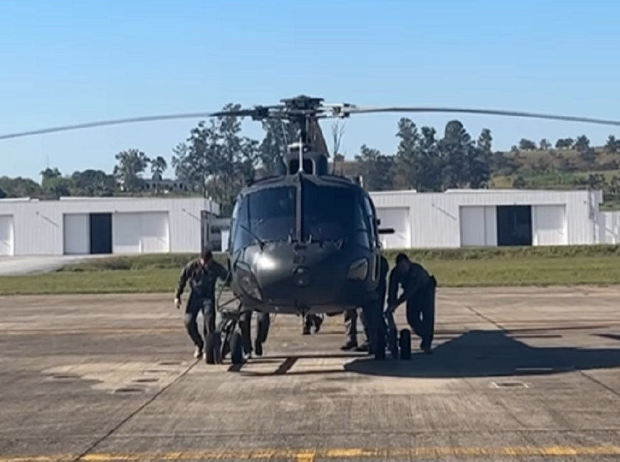 CAvEx de Taubaté envia terceiro helicóptero para operação no Rio Grande do Sul. Foto mostra a aeronave em solo, com militares ao redor.
