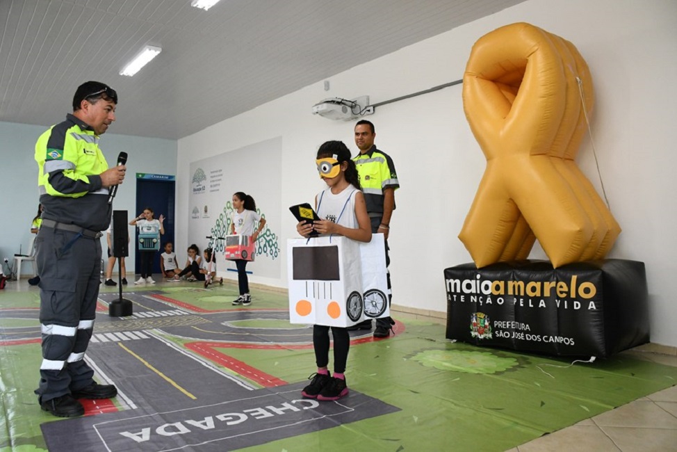 Símbolo do Maio Amarelo ao fundo, em frente uma parede branca; Prefeitura de São José dos Campos inicia ações educativas.