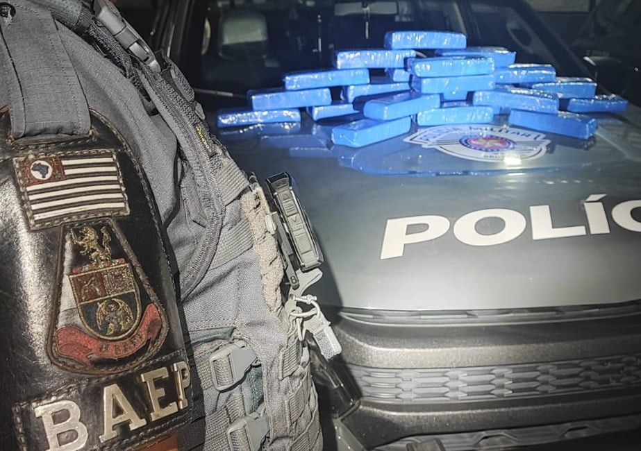 tijolos de maconha sobre o capô de viatura da PM. PM prende foragido, membro do PCC, com 22 tijolos de maconha em São José