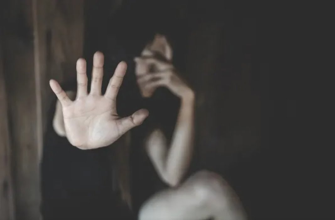 mulher em quarto escuro estica a palma da mão. Homem é preso por violência doméstica e ameaça em Piquete