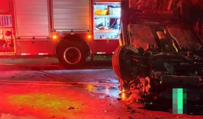 Acidente com carro capotado na pista e caminhão dos bombeiros, luz vermelha predominante