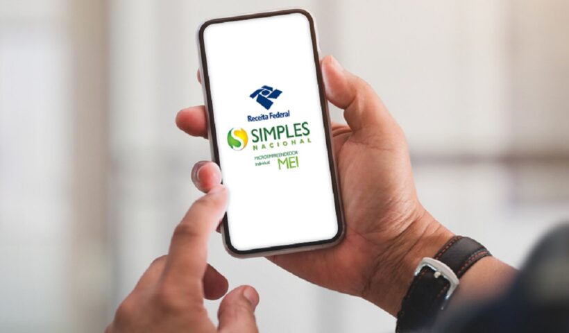 mãos de homem desugrando celular com app do MEI na tela para fazer declaração anual