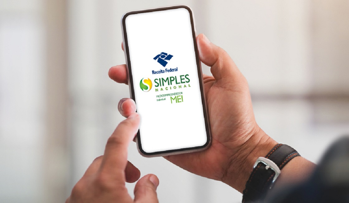 mãos de homem desugrando celular com app do MEI na tela para fazer declaração anual