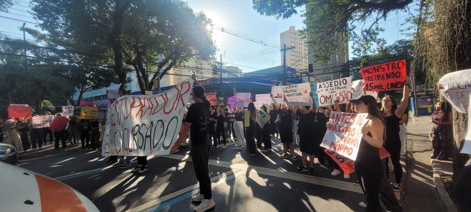 estudantes com cartazes fazendo protesto em semáforo em frete à UNESP de SJC, contra estupro de aluna