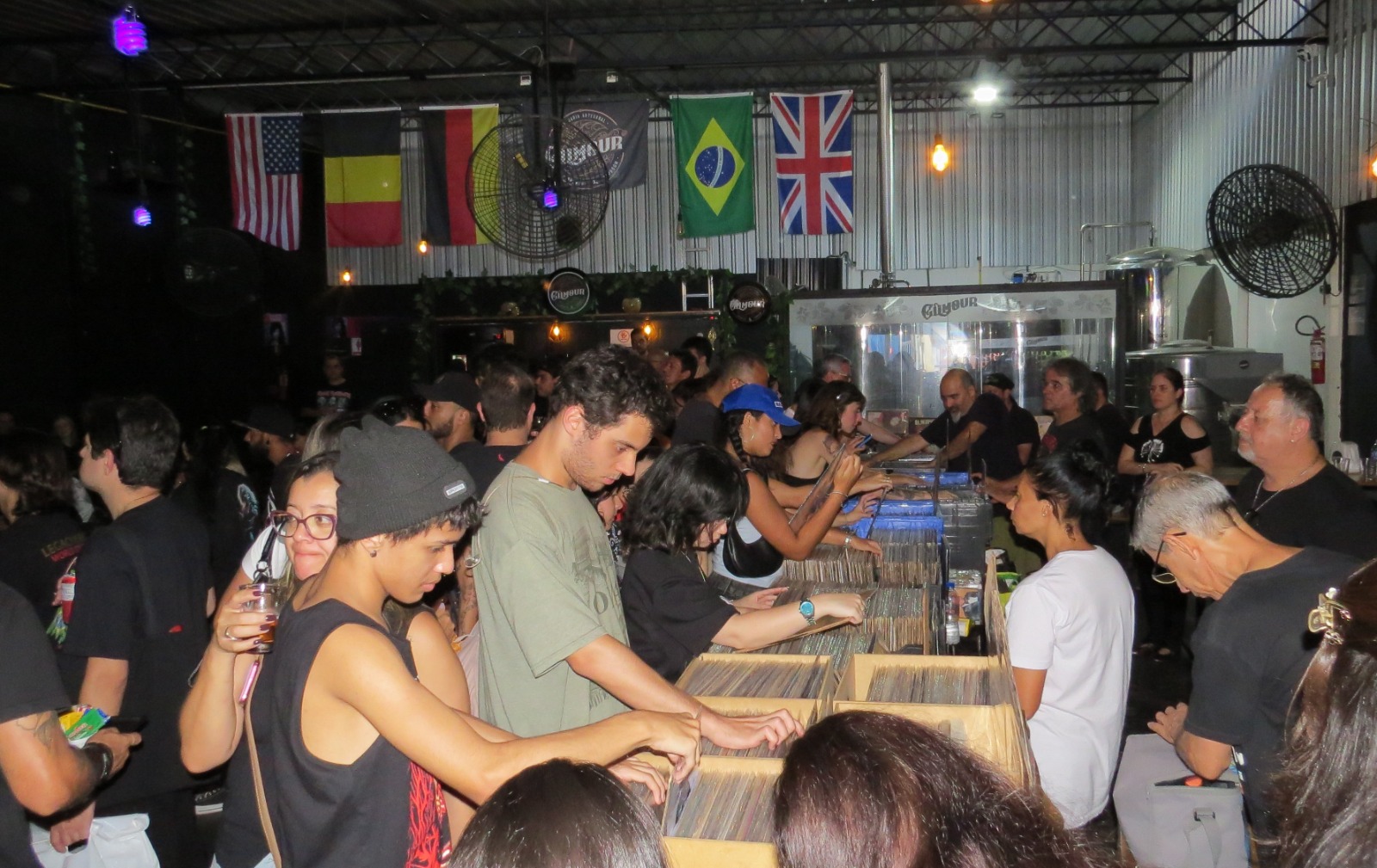 Feira de Discos com clientes pesquisando LPs em caixas de discos