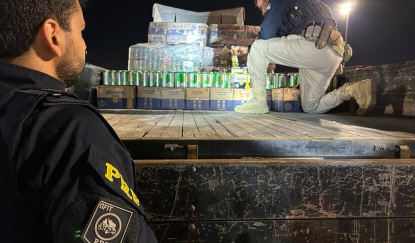 policiral rodoviário federal olha outro colega em cima de caminhão verificando carga de cerveja destinada ao paraguai