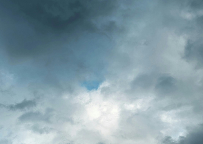 céu com nuvens carregadas de chuva, com sol visível