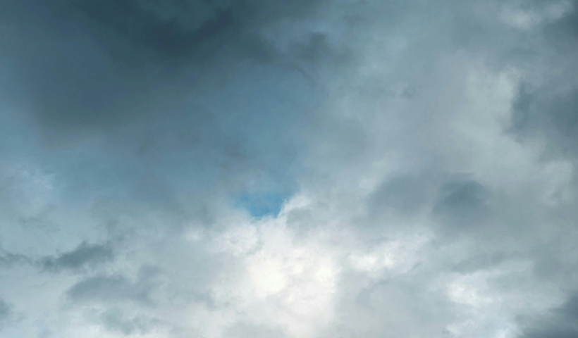 céu com nuvens carregadas de chuva, com sol visível