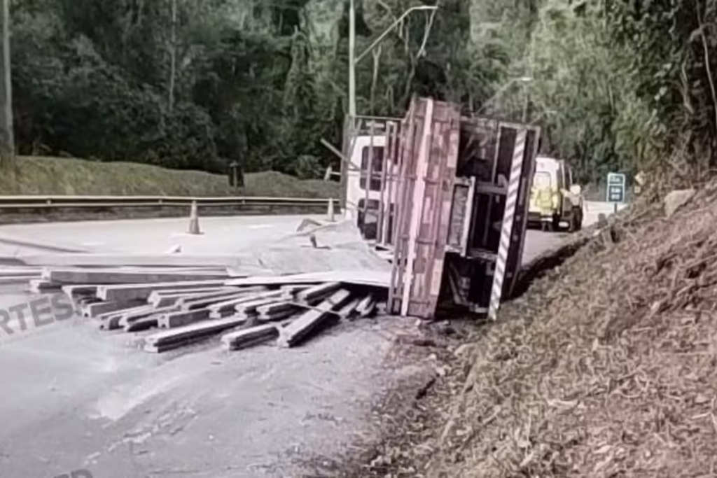 Caminhão tomba na Rodovia dos Tamoios, em Paraibuna (SP), após falha no sistema de freios e causa interdição temporária no sentido litoral.