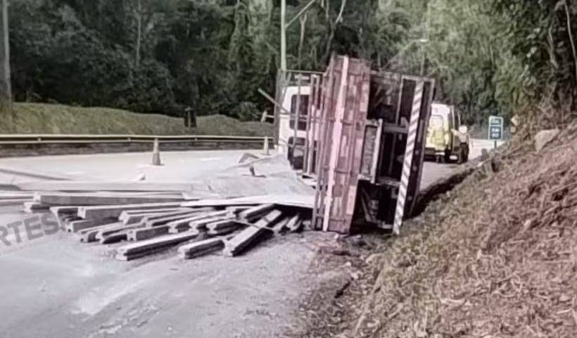 Caminhão tomba na Rodovia dos Tamoios, em Paraibuna (SP), após falha no sistema de freios e causa interdição temporária no sentido litoral.
