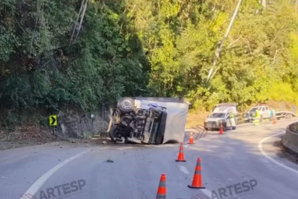 Caminhão tomba na Rodovia dos Tamoios, em Paraibuna, após bater contra barreira de proteção. Motorista saiu ileso.