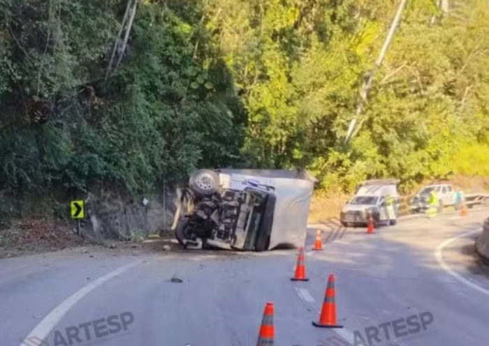 Caminhão tomba na Rodovia dos Tamoios, em Paraibuna, após bater contra barreira de proteção. Motorista saiu ileso.
