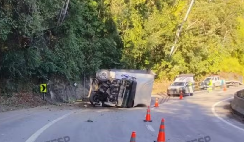 Caminhão tomba na Rodovia dos Tamoios, em Paraibuna, após bater contra barreira de proteção. Motorista saiu ileso.